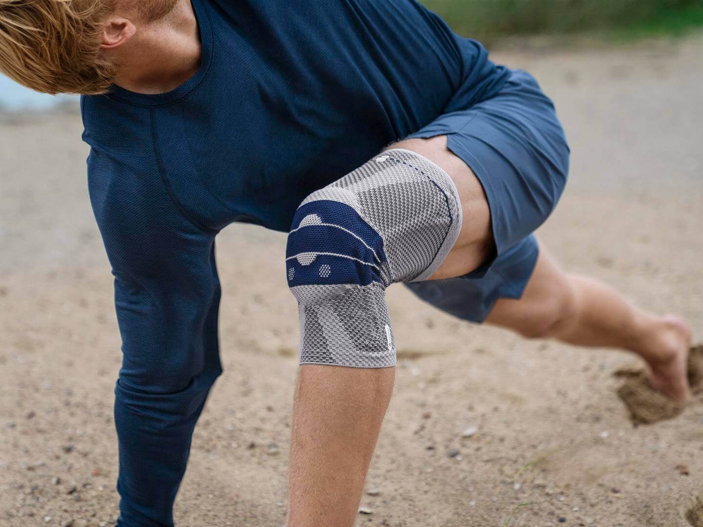 Bildausschnitt eines Mannes mit GenuTrain Bandage am Knie. Diese bietet Entlastung und stabilisiert das Knie, um Schmerzen zu lindern.