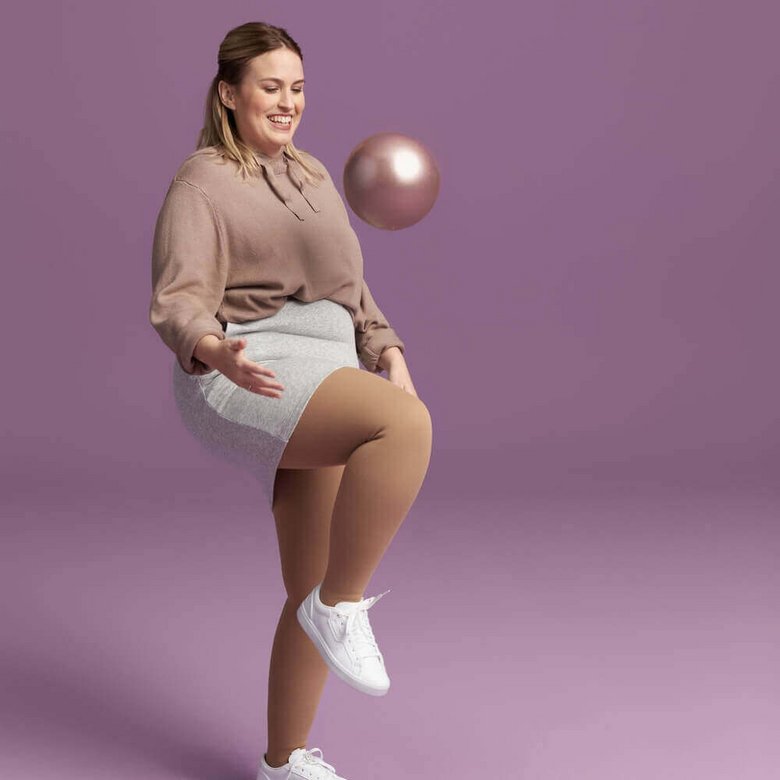  Das Bild zeigt eine Frau, die mit einem Ball spielt. Sie trägt VenoTrain Delight Kompressionsstrümpfe an ihren Beinen.