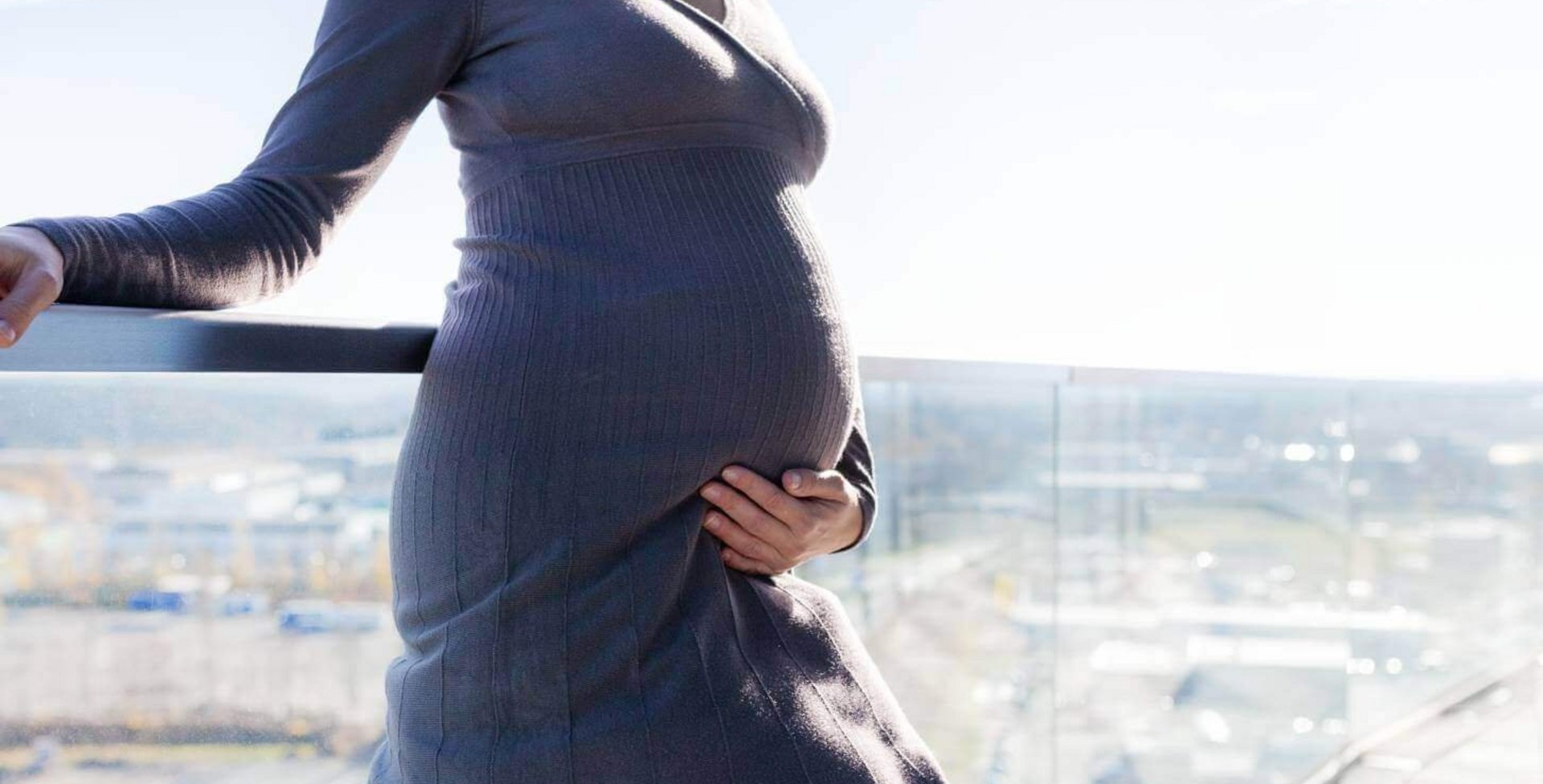 Unterstützung für die Venen Eine schwangere Frau sitzt auf einem Stuhl und liest ein Buch. Ihre Beine hat sie auf einen zweiten Stuhl vor ihr abgelegt. Sie trägt eine VenoTrain® micro Schwangerschaftsstrumpfhose von Bauerfeind welche die werdende Mutter optimal versorgt.